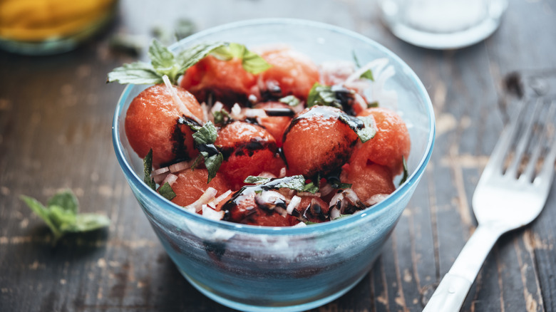 Watermelon balls in a bowl with balsamic drizzle