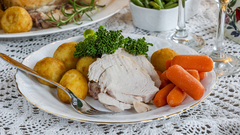 Plate of roasted chicken, potatoes, broccoli, and carrots