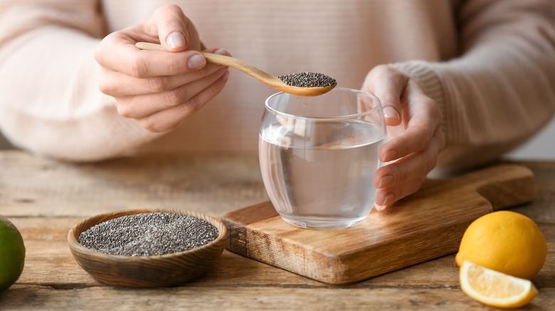 Hand adds chia seeds to water