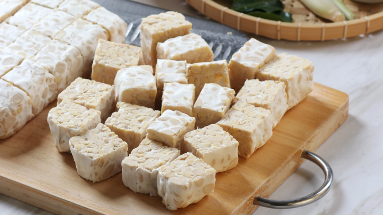 Closeup of cubes of tempeh on a cutting board