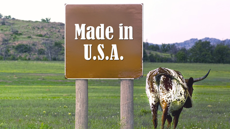 made in the USA sign next to cow in pasture