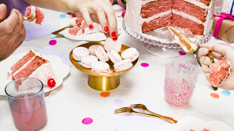 people indulging in pink cake and macarons