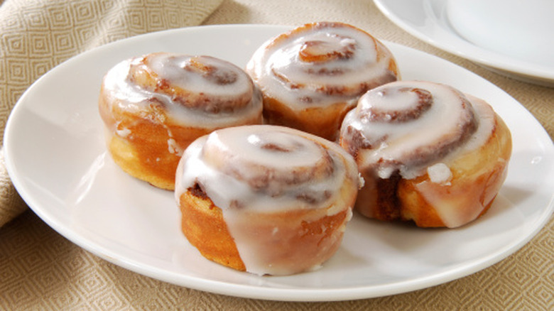 plate of cinnamon rolls topped with icing