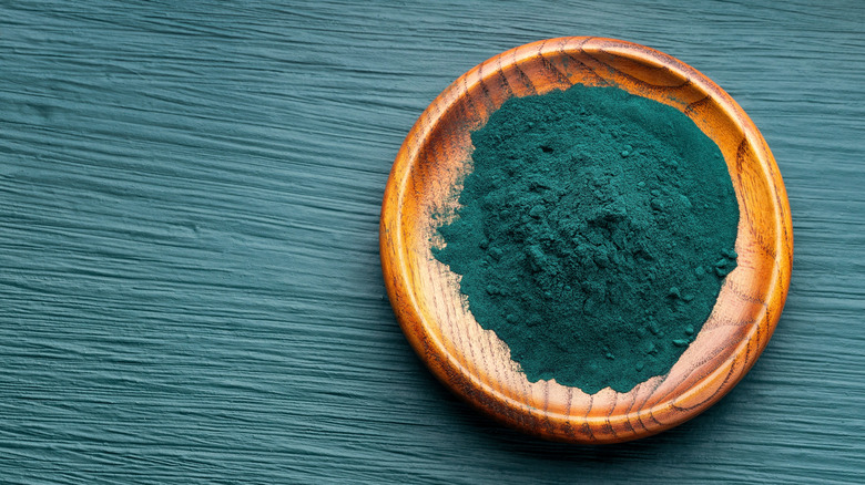 blue spirulina powder on a wooden dish