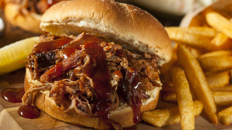 Close up of BBQ pulled pork sandwich with fries 