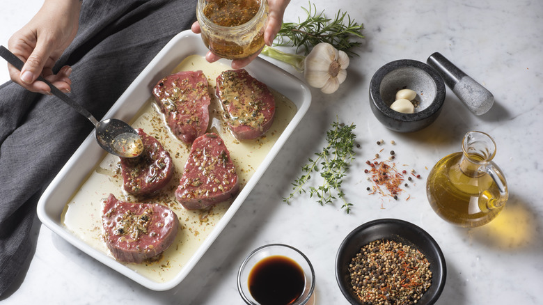 Hand spooning marinade on meat