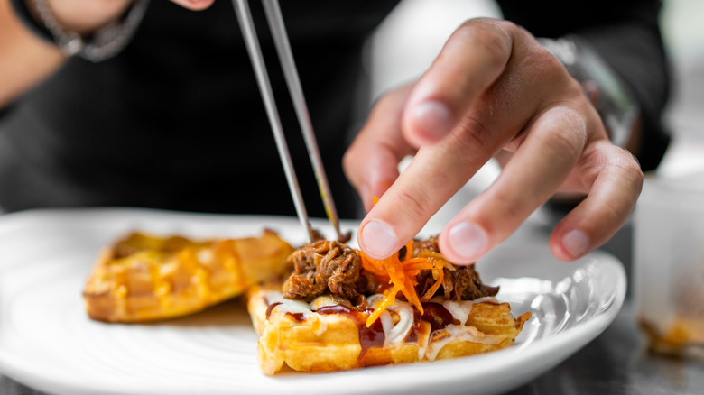 Plating mini waffle appetizers with pulled pork