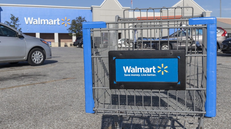 A Walmart-branded shopping cart in a Walmart parking lot
