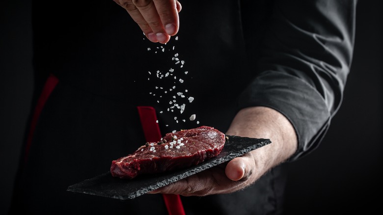 chef seasoning steak 