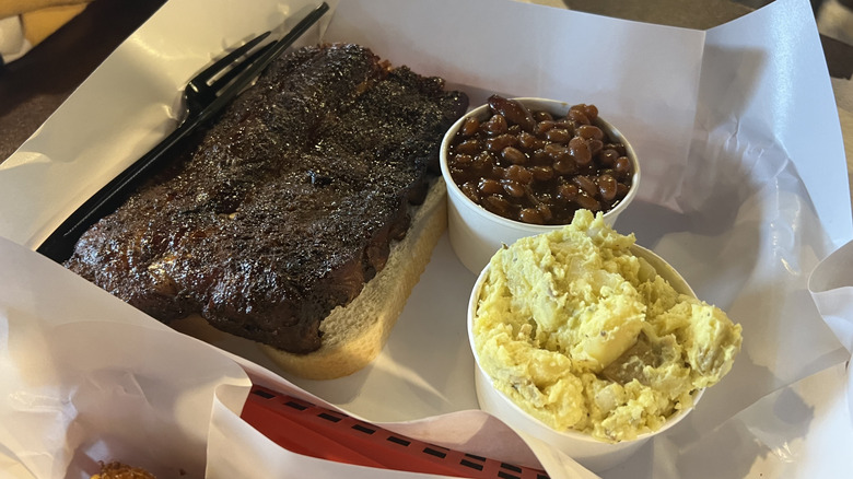 Paper-lined tray with short ribs, white bread, baked beans, and potato salad at Pappy's Smokehouse