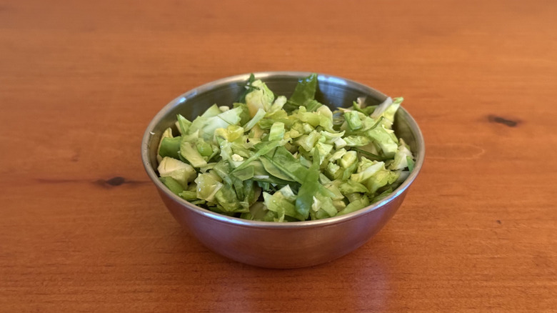 Stainless steel bowl with raw, chopped Brussels sprouts
