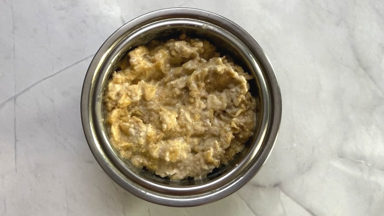 Steel bowl full of bircher muesli with creamy, moist texture