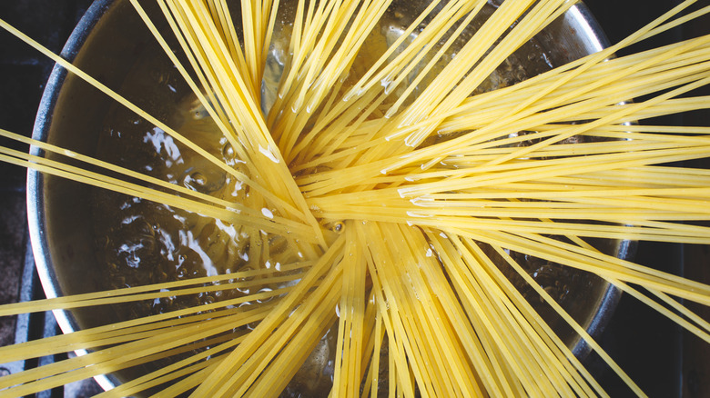 uncooked spaghetti noodles in a stock pot of water