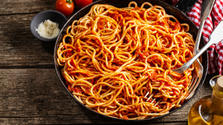 spaghetti and marinara sauce in a cast iron skillet