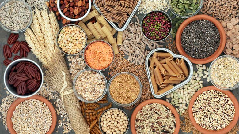 Containers of grains, nuts, seeds, and pastas and loose ingredients filling the frame