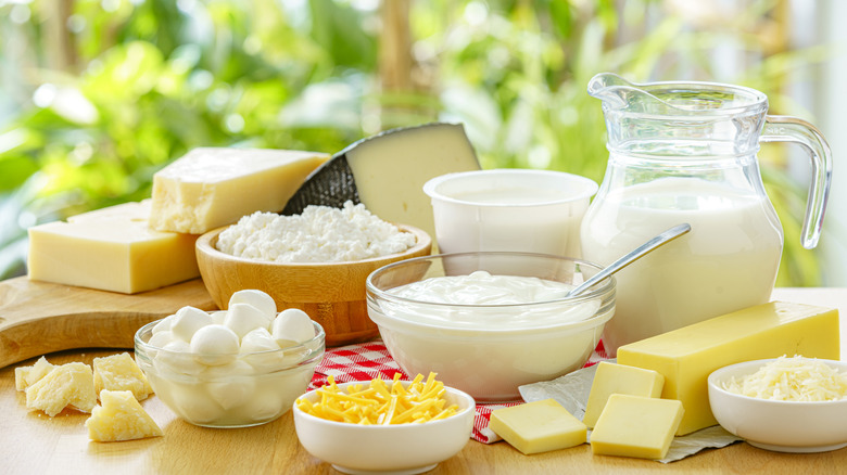 A variety of dairy products like milk, cheese, and butter on a table outdoors