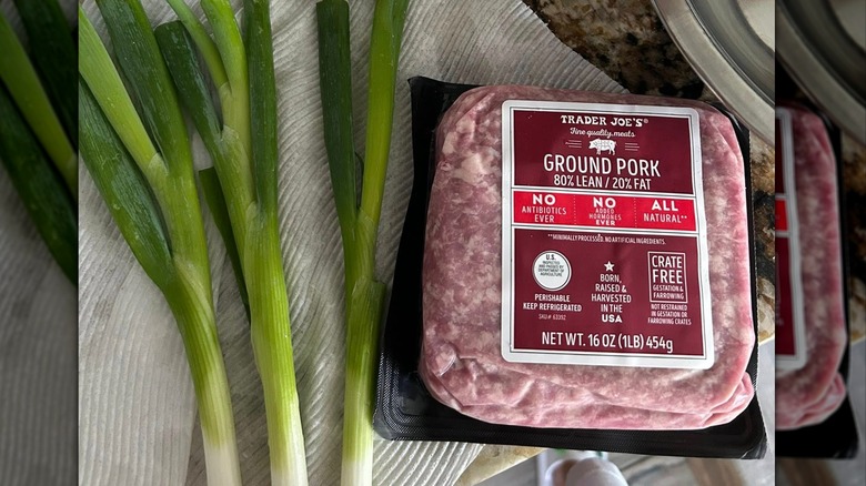Trader Joe's raw ground pork next to green scallions