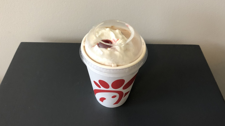 Chick-fil-A chocolate shake with whipped cream and cherry.