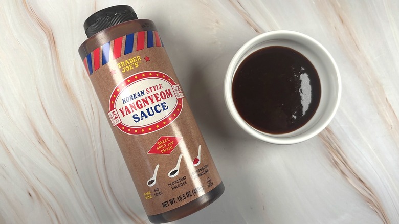 Overhead shot of Trader Joe's Yangnyeom Sauce in white dish next to bottle on table