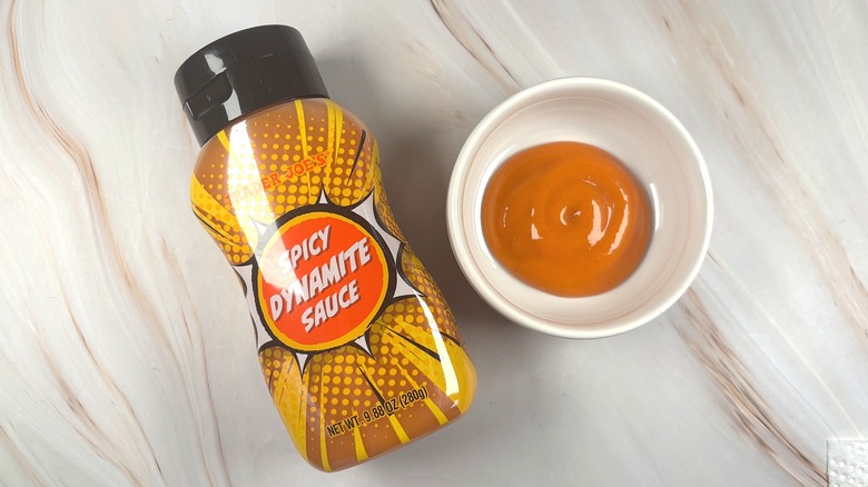 Overhead shot of Trader Joe's Spicy Dynamite Sauce in white dish next to bottle on table