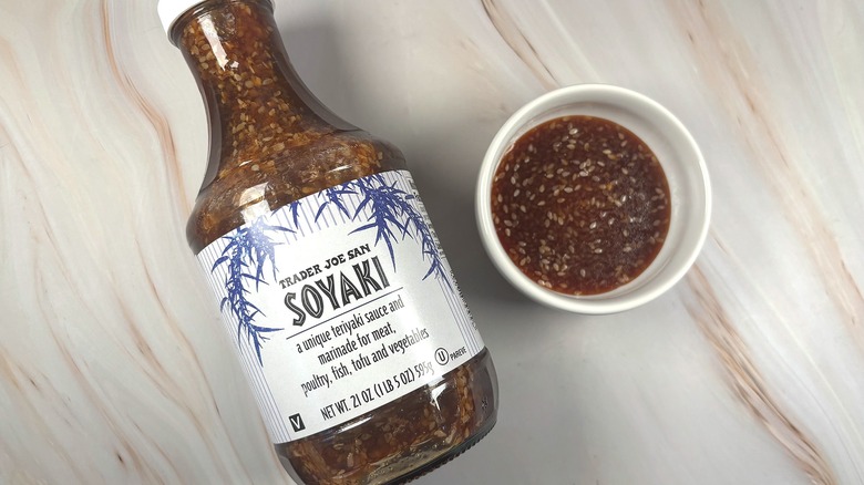 Overhead shot of Trader Joe's Soyaki Sauce in white dish next to bottle on table