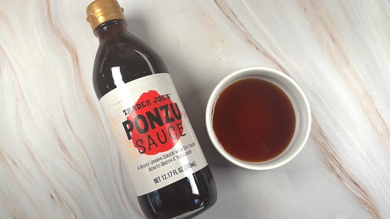 Overhead shot of Trader Joe's Ponzu Sauce in white dish next to bottle on table