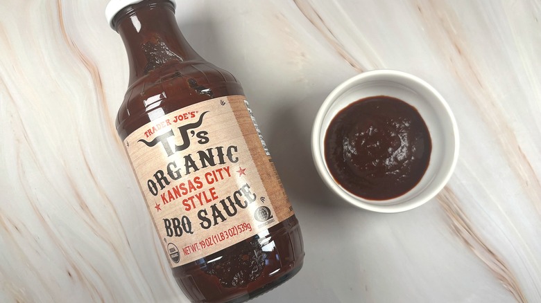 Overhead shot of Trader Joe's Kansas City Style BBQ Sauce in white dish next to bottle on table
