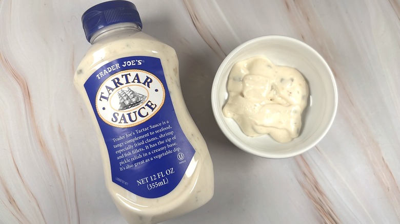 Overhead shot of Trader Joe's Tartar Sauce in white dish next to bottle on table