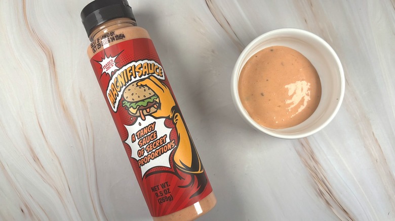 Overhead shot of Trader Joe's Magnifisauce Sauce in white dish next to bottle on table