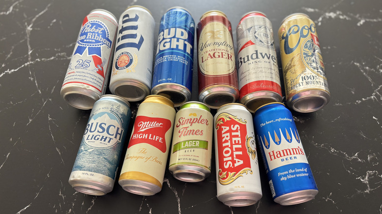 Various beer cans laid on a dark countertop