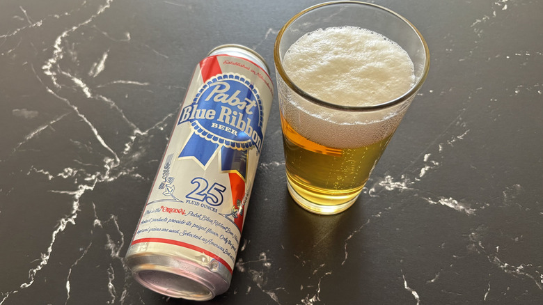 Pabst Blue Ribbon can next to glass of beer