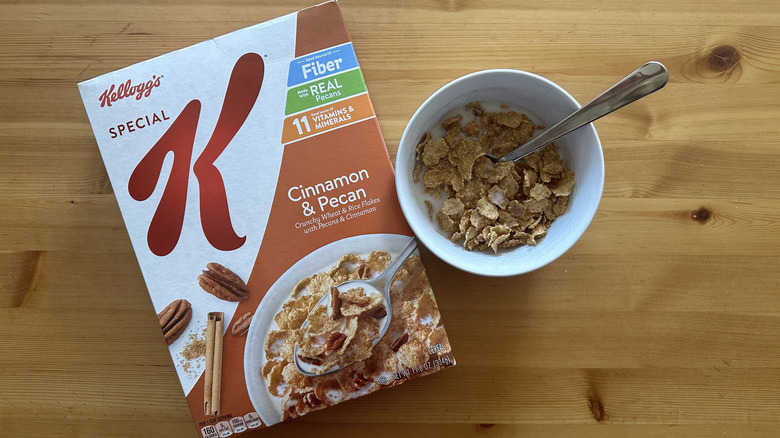 Special K Cinnamon and Pecan cereal in a box and mixed with milk inside a white bowl on a table