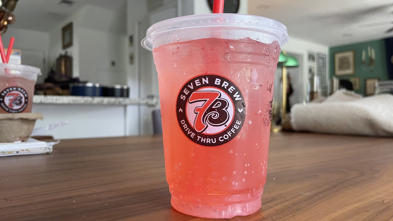 Pink mermaid soda in a cup on a wooden table