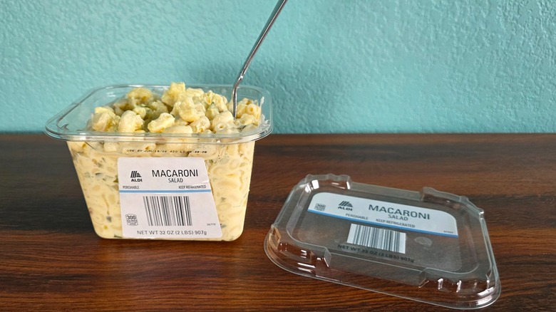Container of Aldi macaroni salad open on table with spoon