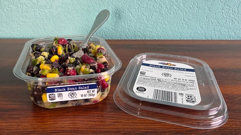 Container of Park Street deli black bean salad open on table with spoon