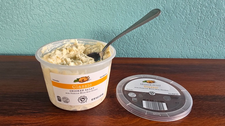 Container of Park Street deli classic chicken salad open on table with spoon