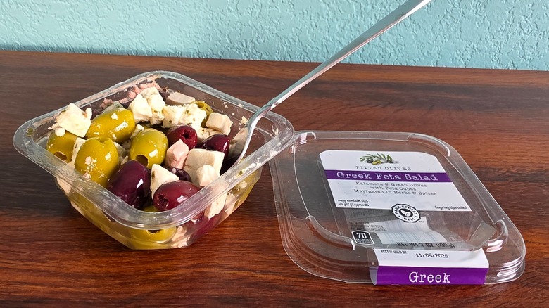 Container of Park Street deli Greek feta salad open on table with spoon