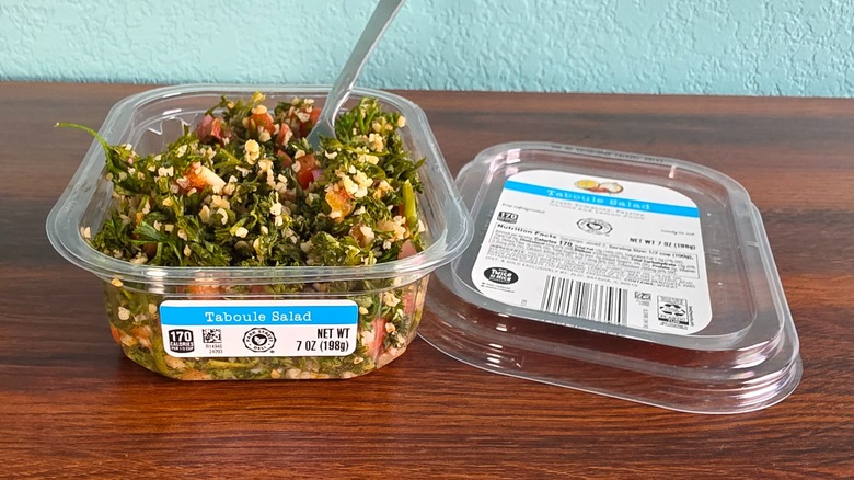 Container of Park Street deli taboule salad open on table with spoon