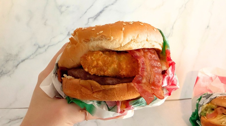 Hand holding Carl's Jr. Single El Diablo against white background