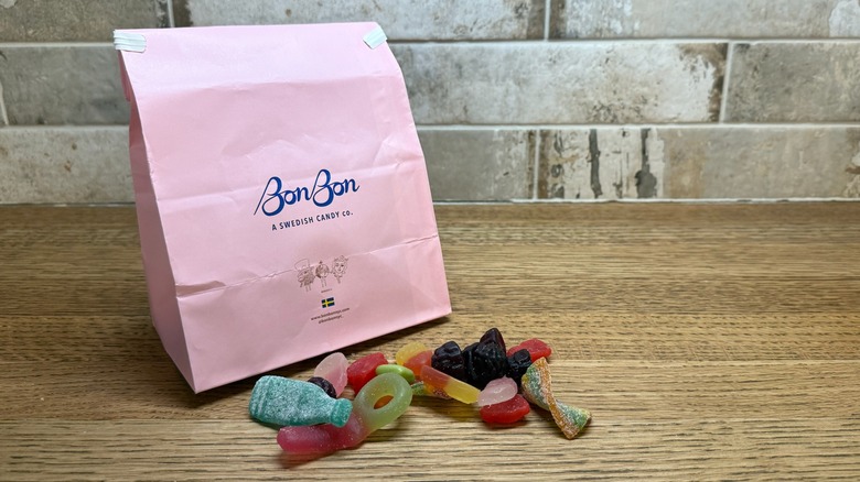 bag of BonBon candy with various candies laying on table in front of it