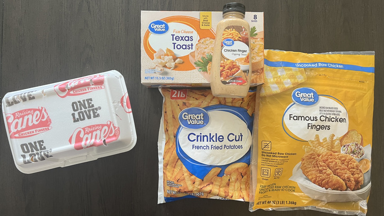 Raising Cane's box and Great Value chicken, fries, toast, and sauce on a dark table