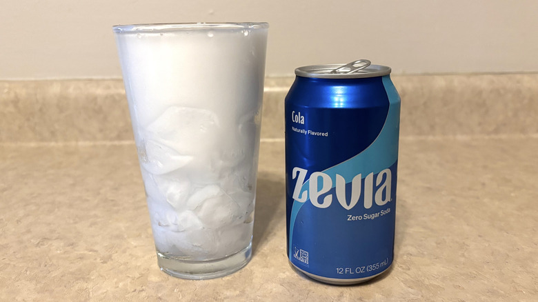 Zevia cola in can and glass on neutral countertop