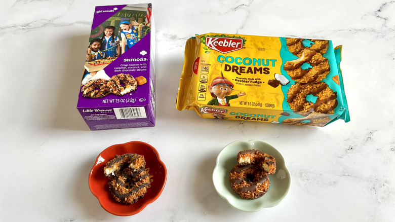 Girl Scout Samoa cookie box next to Keebler Coconut Dreams cookie package with cookies on plates in front