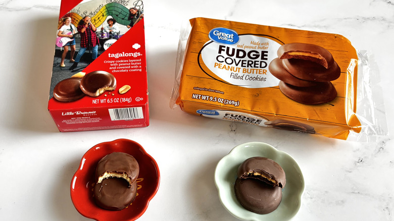 Girl Scout Tagalongs cookie box next to Great Value fudge peanut butter cookies package with cookies on plates in front