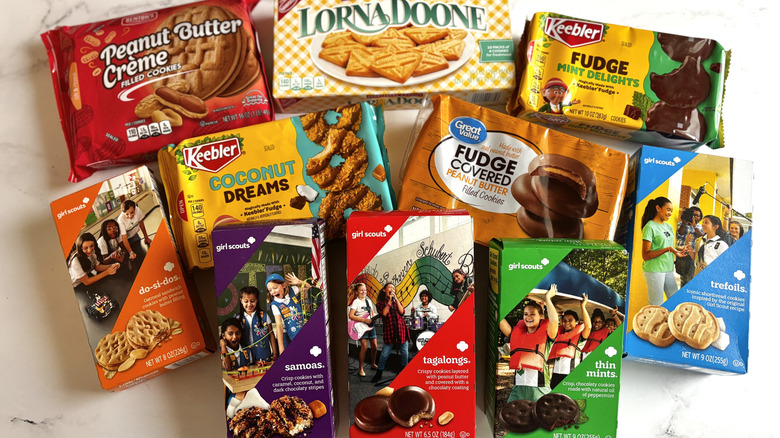 Various Girl Scout cookie boxes and store-bought cookie packages on countertop