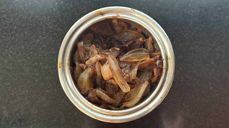 Stainless steel bowl of braised caramelized onions