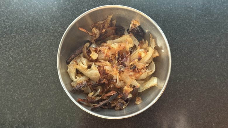 Stainless steel bowl of baked caramelized onions