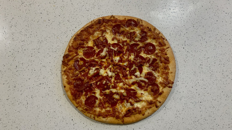 Baked 7-Eleven pepperoni pizza on top of white granite countertop