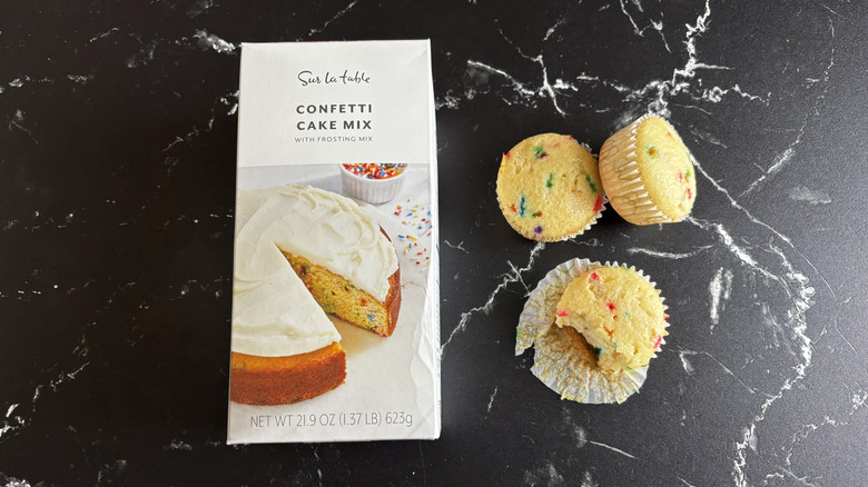 Sur La Table cake mix box next to baked confetti cupcakes with one cupcake half eaten