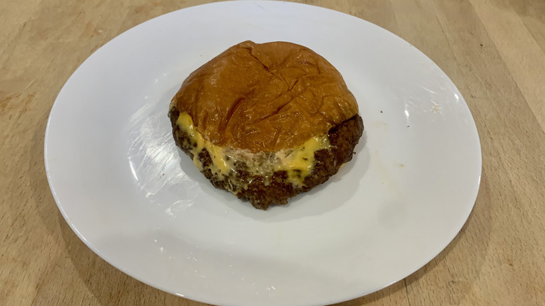 Skinny Louie burger on white plate on wood table